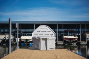 white heavy-duty plastic storage container open lid on boat dock